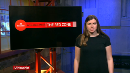 Mary Claire Molloy standing in front of a screen that says "The Red Zone"