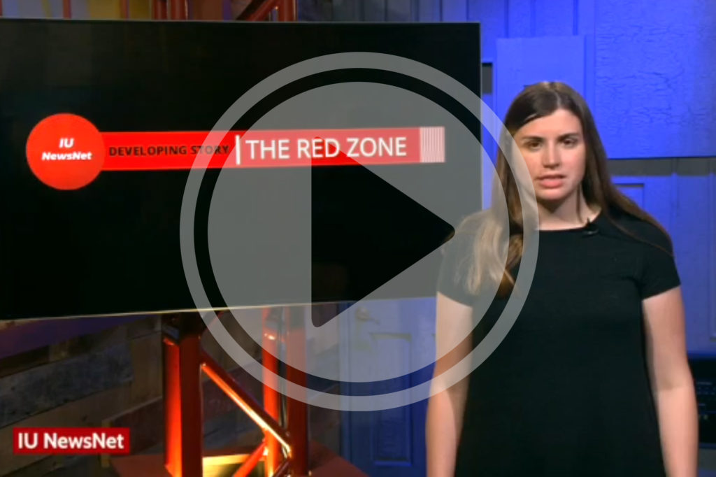 Mary Claire Molloy standing in front of a screen that says "The Red Zone"