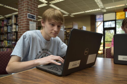 Tyler Dwenger checks his grades for his final semester of high school on his school-issued laptop. Photo by Mitchell Lierman