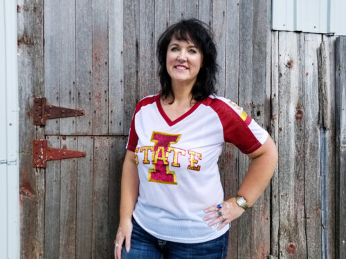 Darcy Maulsby, a fifth-generation Calhoun County, Iowa farmer, stands in front of a barn on her family's 135-year-old farm. photo provided by Darcy Maulsby