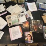 The kitchen table at the home of Paul and Diane Cotter is covered in media articles about their advocacy as well as color-coded binders containing documents related to PFAS in turnout gear that Diane has been amassing for years.